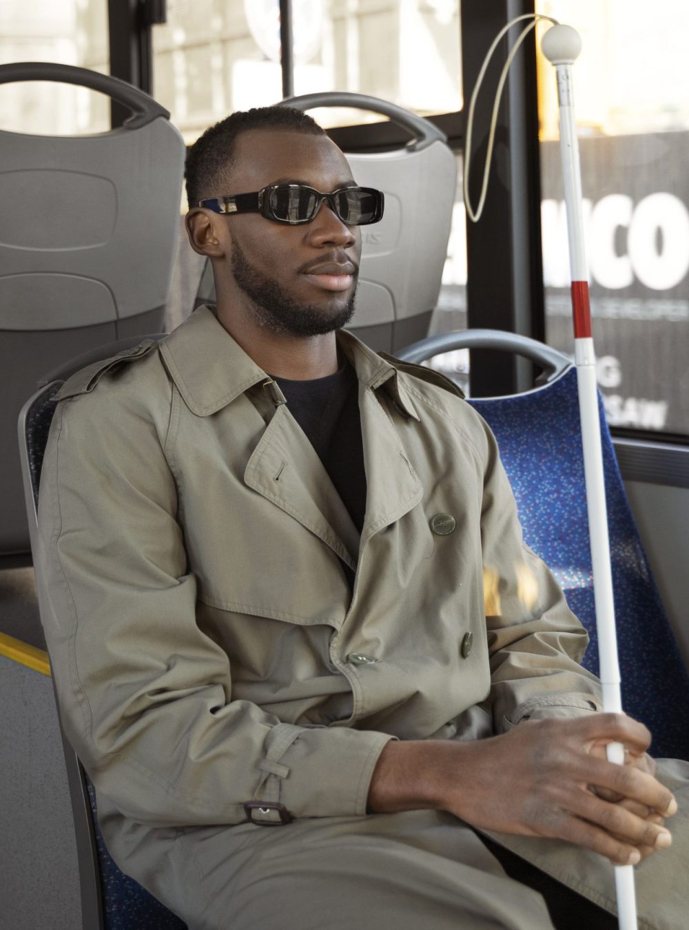 Homme malvoyant assis dans un bus
