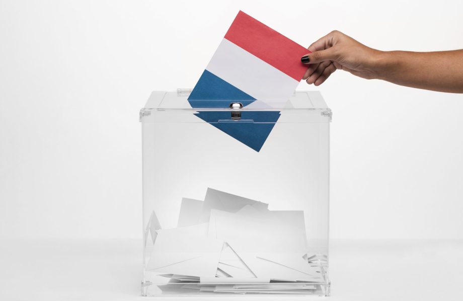 Personne mettant un bulletin au couleur de la France dans une urne afin de voter