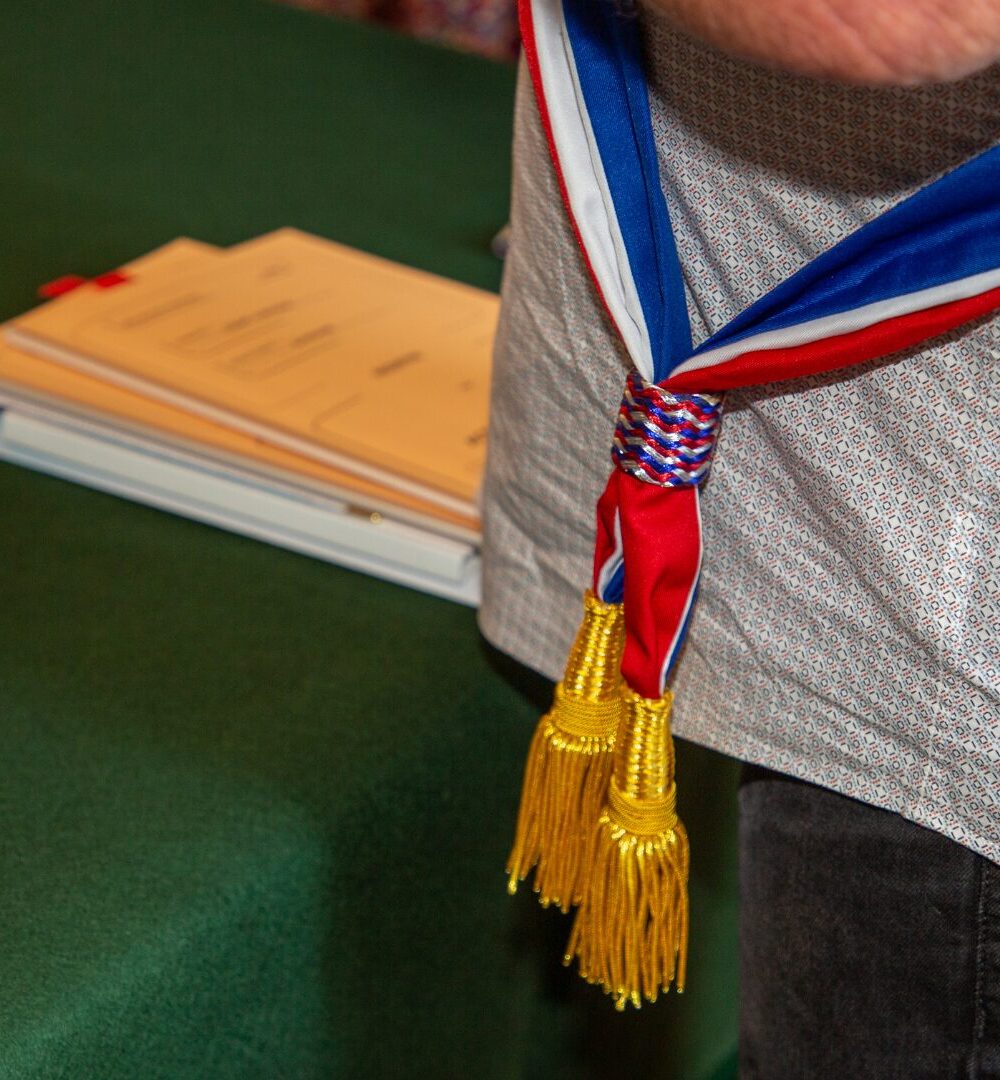 Plan rapproché sur un élu portant une écharpe bleu blanc rouge dans le cadre de sa fonction
