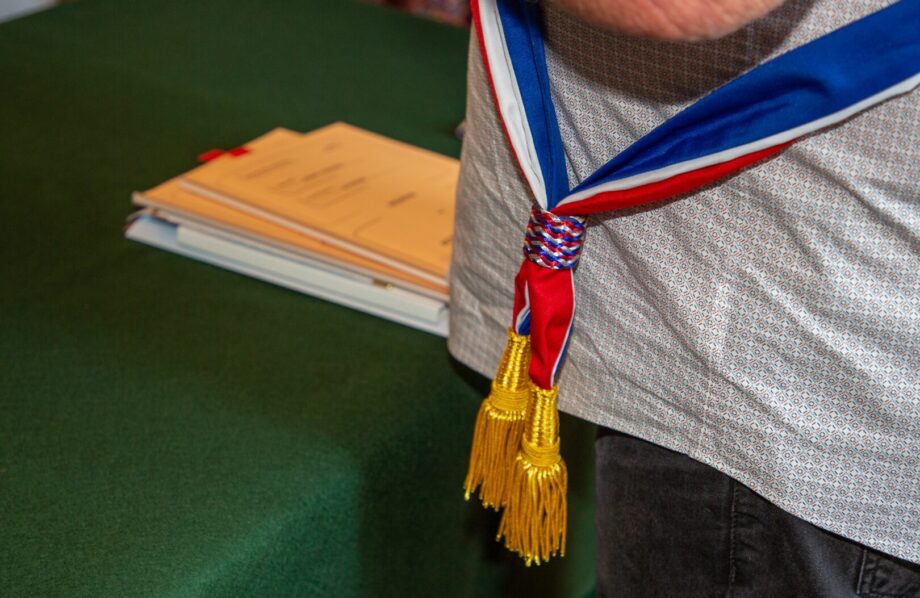 Plan rapproché sur un élu portant une écharpe bleu blanc rouge dans le cadre de sa fonction