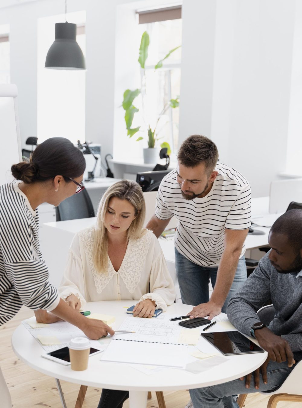 Une équipe échange autour de documents et d’un ordinateur lors d’un travail collaboratif.